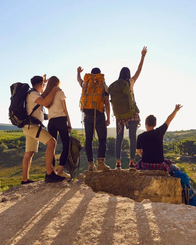 Group of travelers celebrating on a hilltop